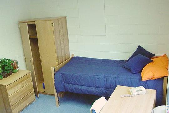 Keystone College dorm room with bed, desk and clothes closet.